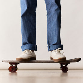 fit model on a skateboard in The Morse Pant in Bleached Indigo Herringbone