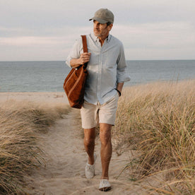 fit model walking on the beach wearing The Apres Short in Organic Aged Stone Foundation Twill