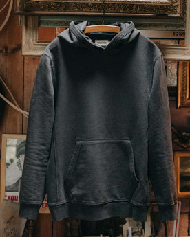 The Cotton Hemp Hoodie in Asphalt hanging in a studio, Knits by Taylor Stitch