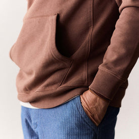 fit model showing the kangaroo pocket on The Cotton Hemp Hoodie in Faded Brick