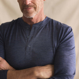 fit model with his arms crossed wearing The Merino Henley in Heather Navy