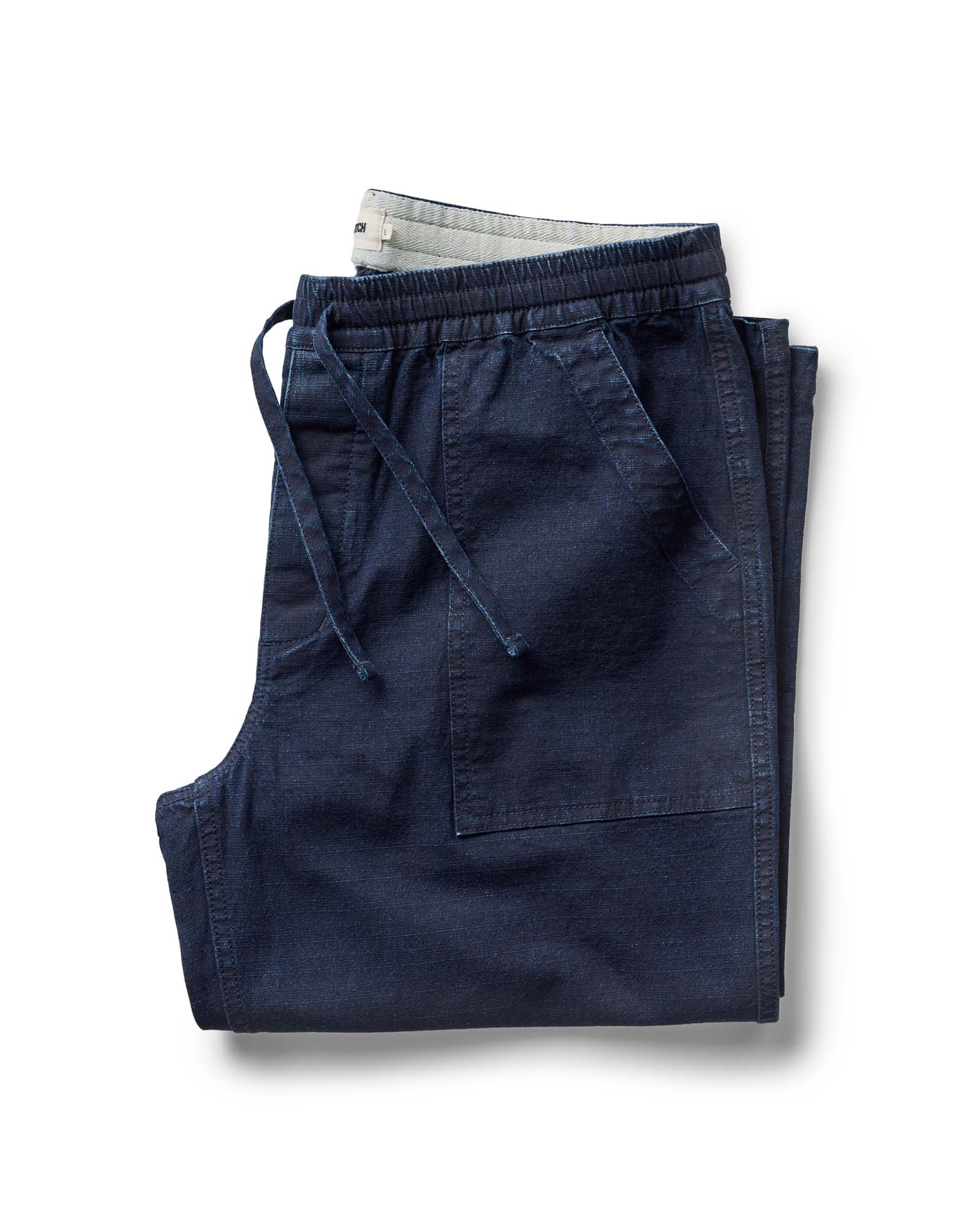folded flatlay of The Breakwater Pant in Rinsed Indigo Ripstop, Bottoms by Taylor Stitch