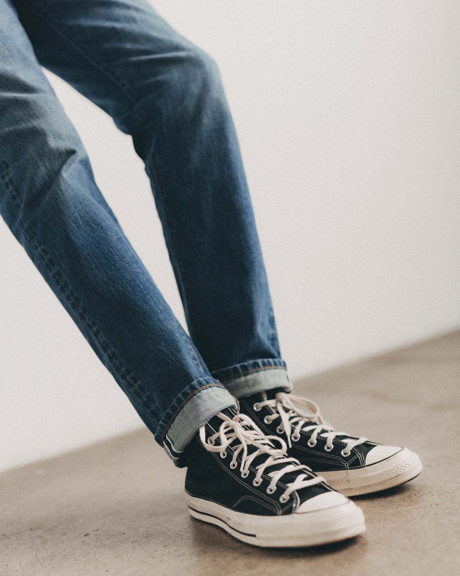 fit model holding plants wearing The Slim Jean in Mid Wash Organic Selvedge, Bottoms by Taylor Stitch