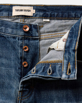 fit model walking in The Slim Jean in Mid Wash Organic Selvedge, Bottoms by Taylor Stitch