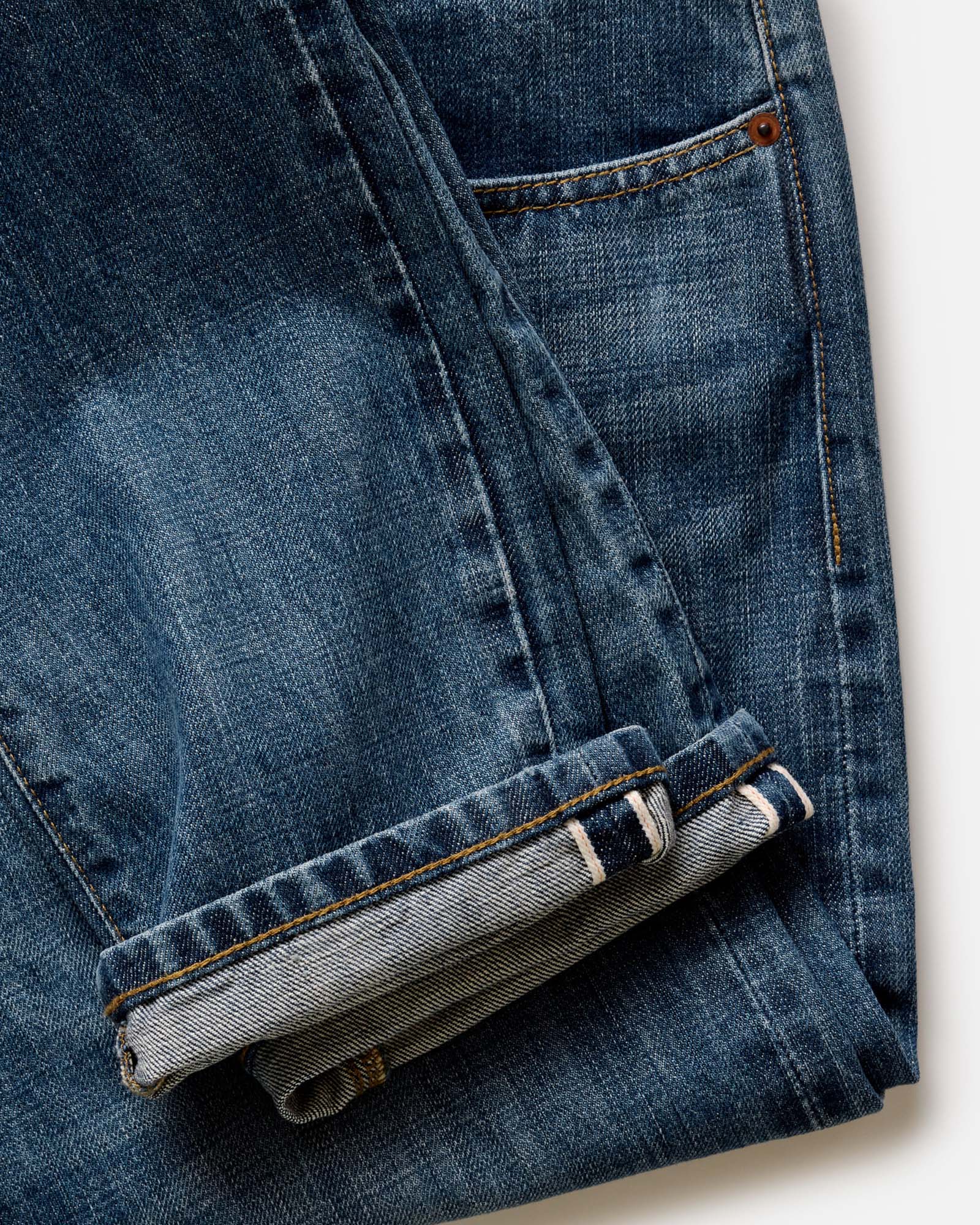 folded flatlay of the back of The Slim Jean in Mid Wash Organic Selvedge, Bottoms by Taylor Stitch