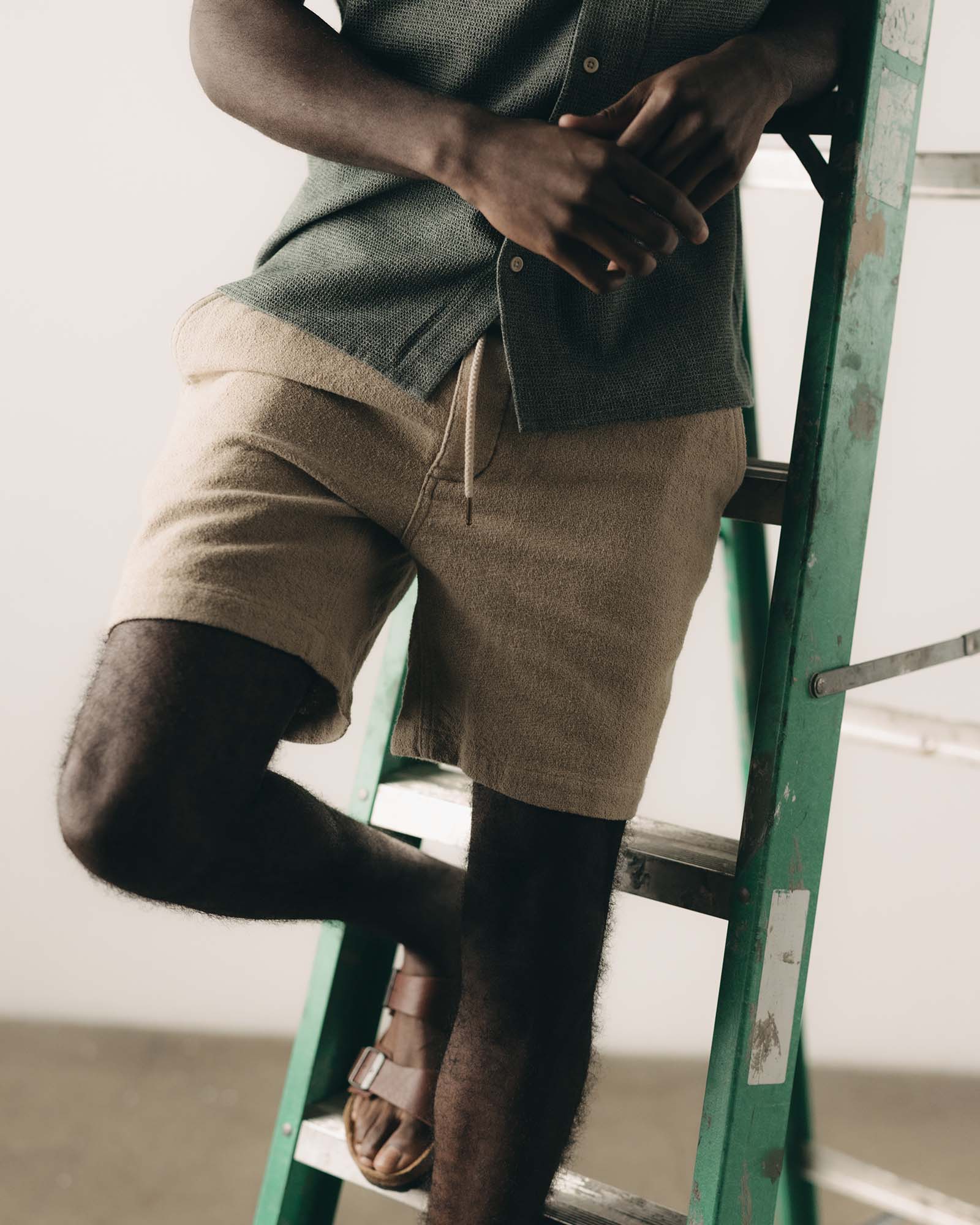 fit model posing on a ladder in The Apres Short in Heather Oat Crepe, Bottoms by Taylor Stitch