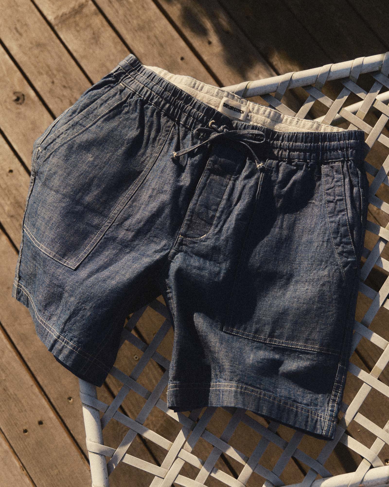 fit model walking wearing The Breakwater Short in Washed Indigo Chambray, Bottoms by Taylor Stitch