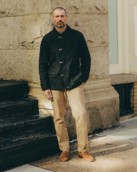 fit model posing in The Cinder Jacket in Coal Dry Wax, Outerwear by Taylor Stitch