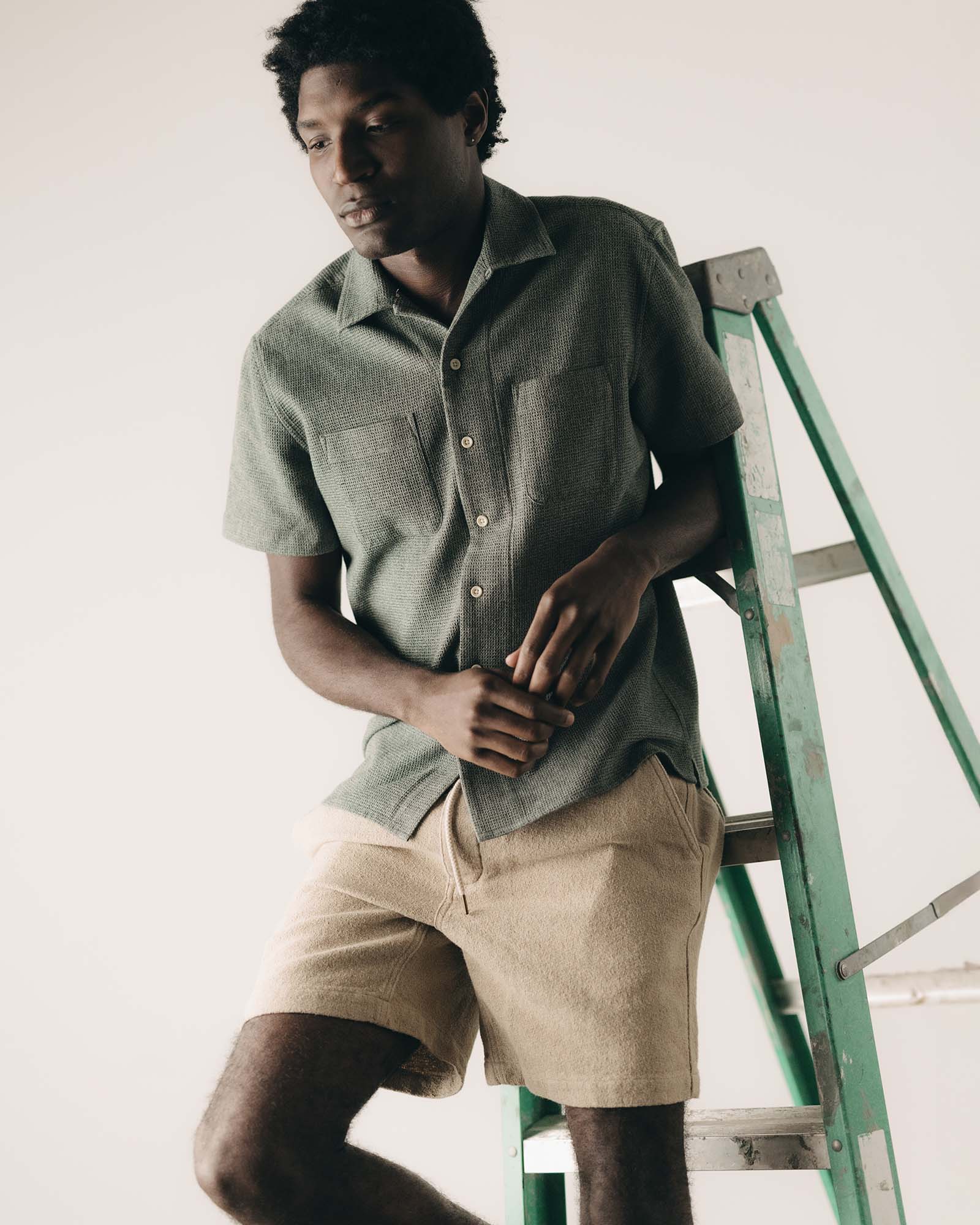 fit model leaning against the wall wearing The Conrad Shirt in Deep Sea Twist, Wovens by Taylor Stitch