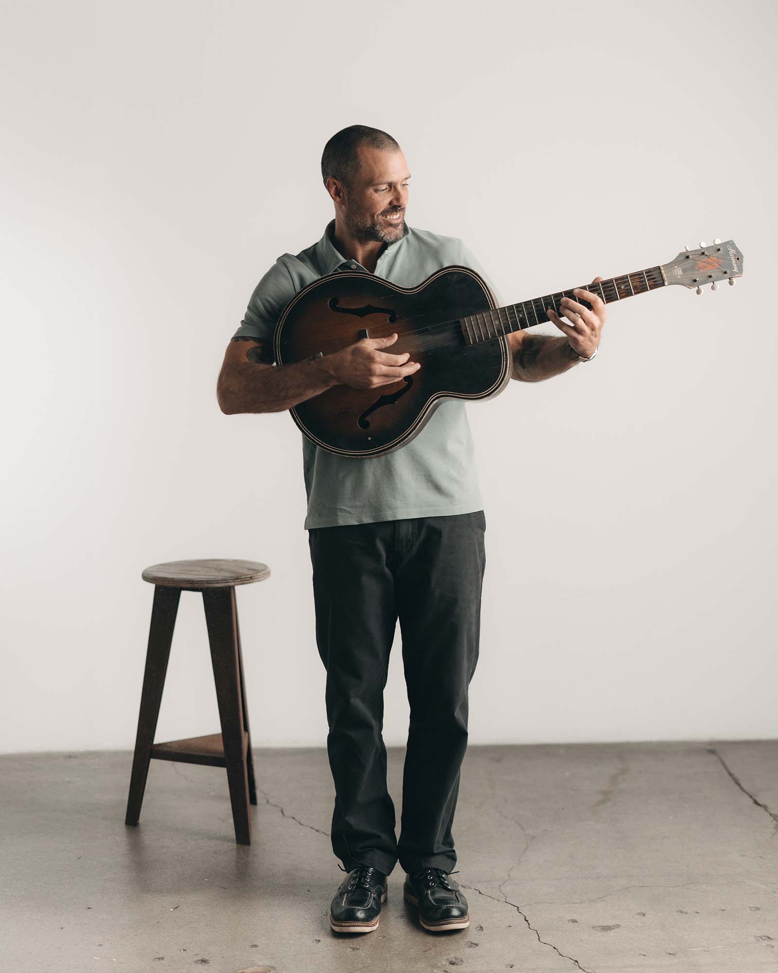 fit model holding a guitar wearing The Cotton Hemp Polo in Surf Green Pique, Knits by Taylor Stitch