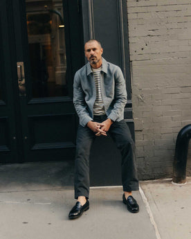 fit model sitting wearing The Straight Foundation Pant in Organic Faded Black, Bottoms by Taylor Stitch