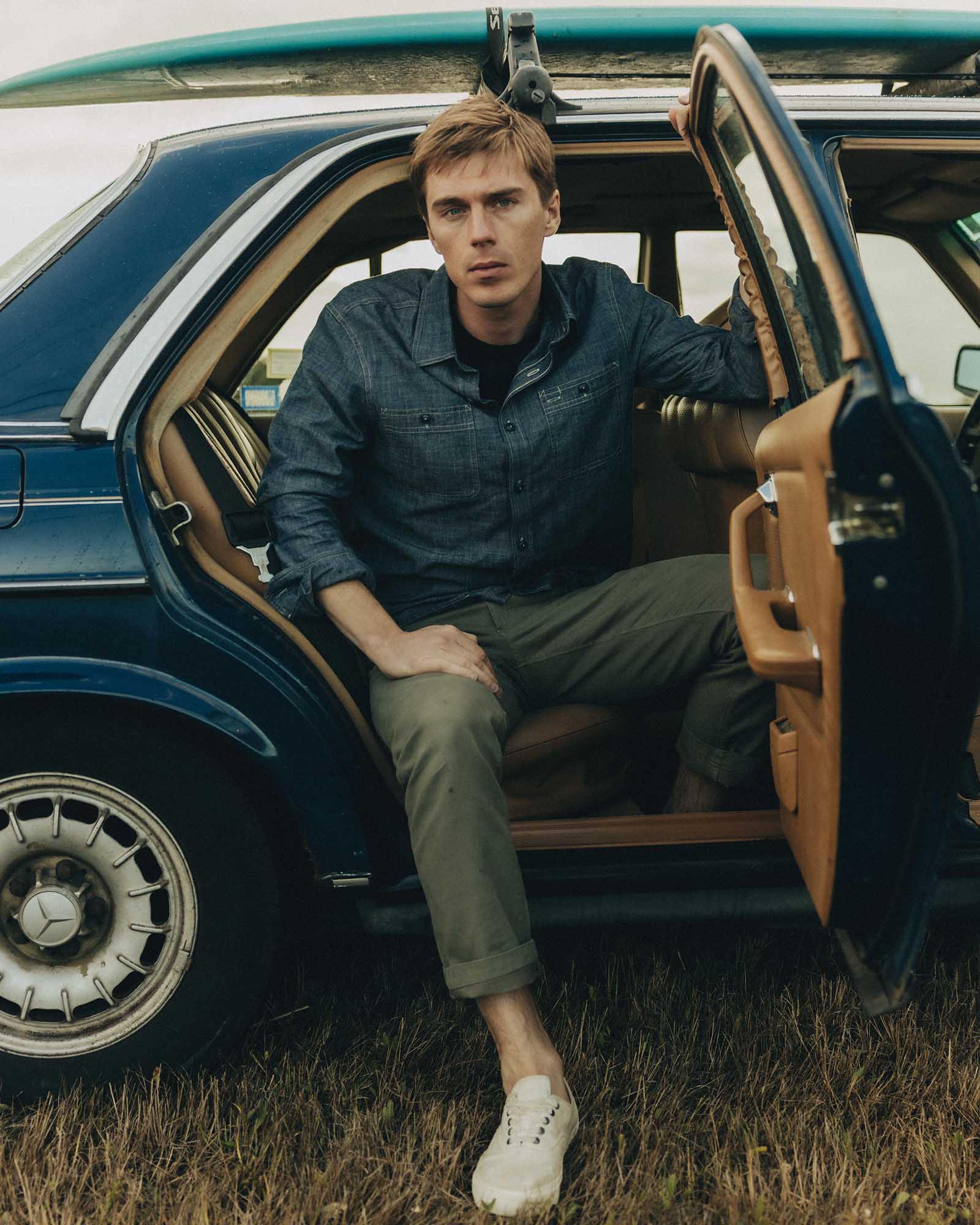 fit model sitting wearing The Straight Foundation Pant in Organic Smoked Olive, Bottoms by Taylor Stitch