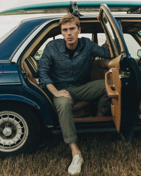 fit model sitting wearing The Straight Foundation Pant in Organic Smoked Olive, Bottoms by Taylor Stitch