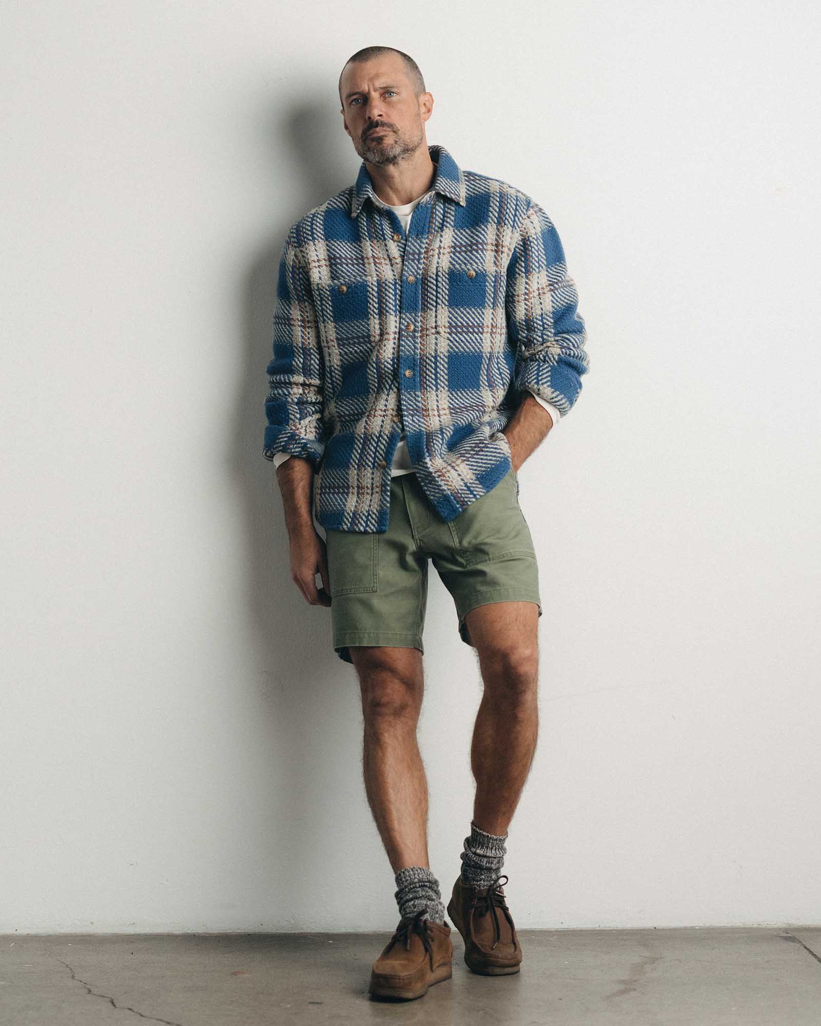 fit model leaning against the wall wearing The Surplus Short in Field Olive Reverse Sateen, Bottoms by Taylor Stitch