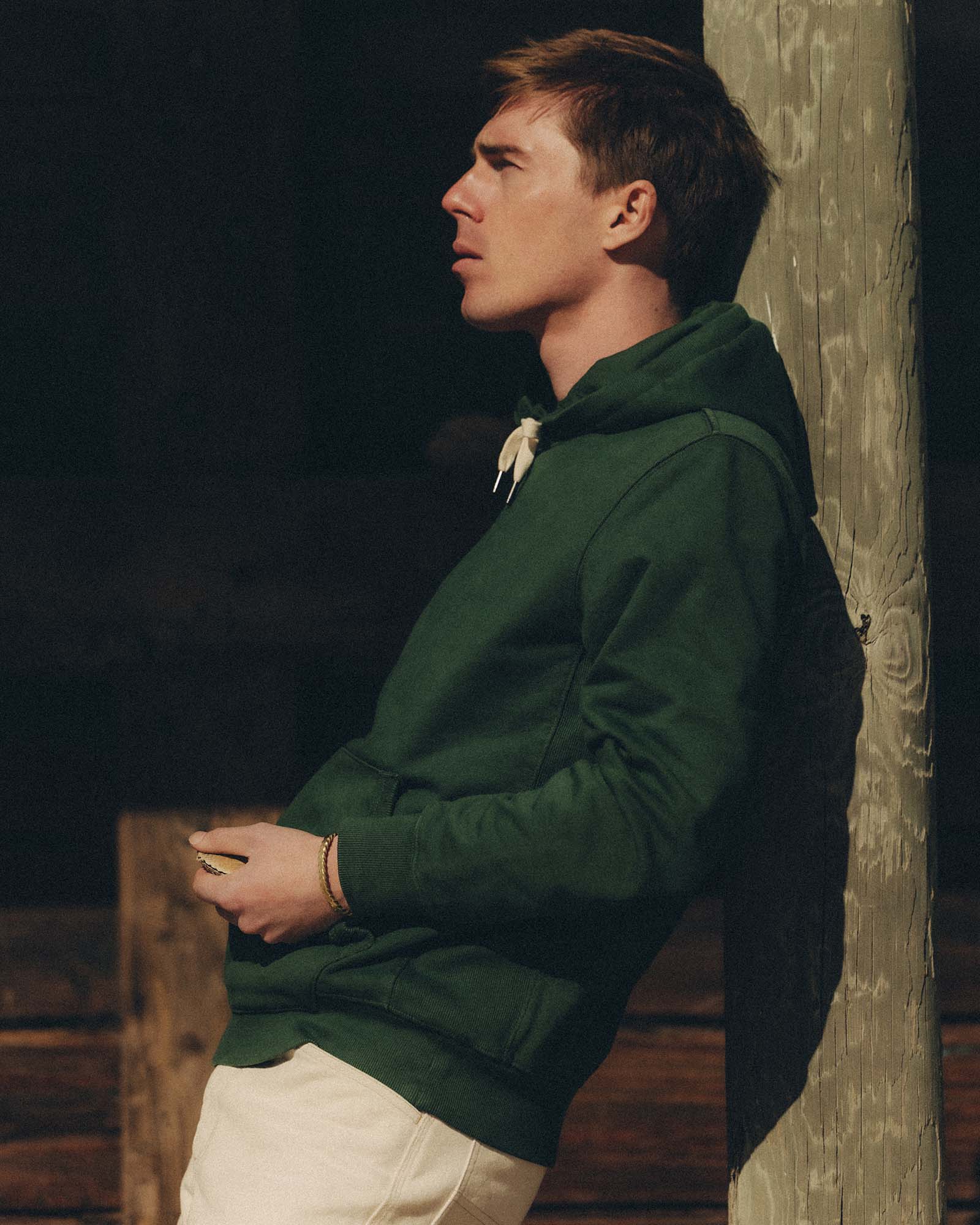fit model leaning against a pole wearing The Shop Hoodie in Ivy French Terry, Knits by Taylor Stitch