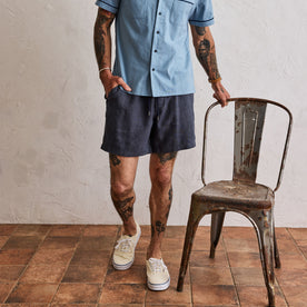 fit model standing by a metal chair in The Apres Short in Marine Hemp