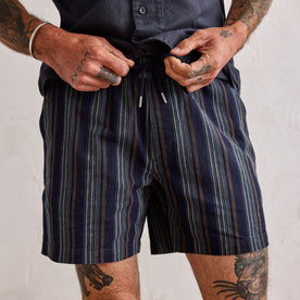 fit model tying the drawcords on The Apres Short in Indigo Stripe