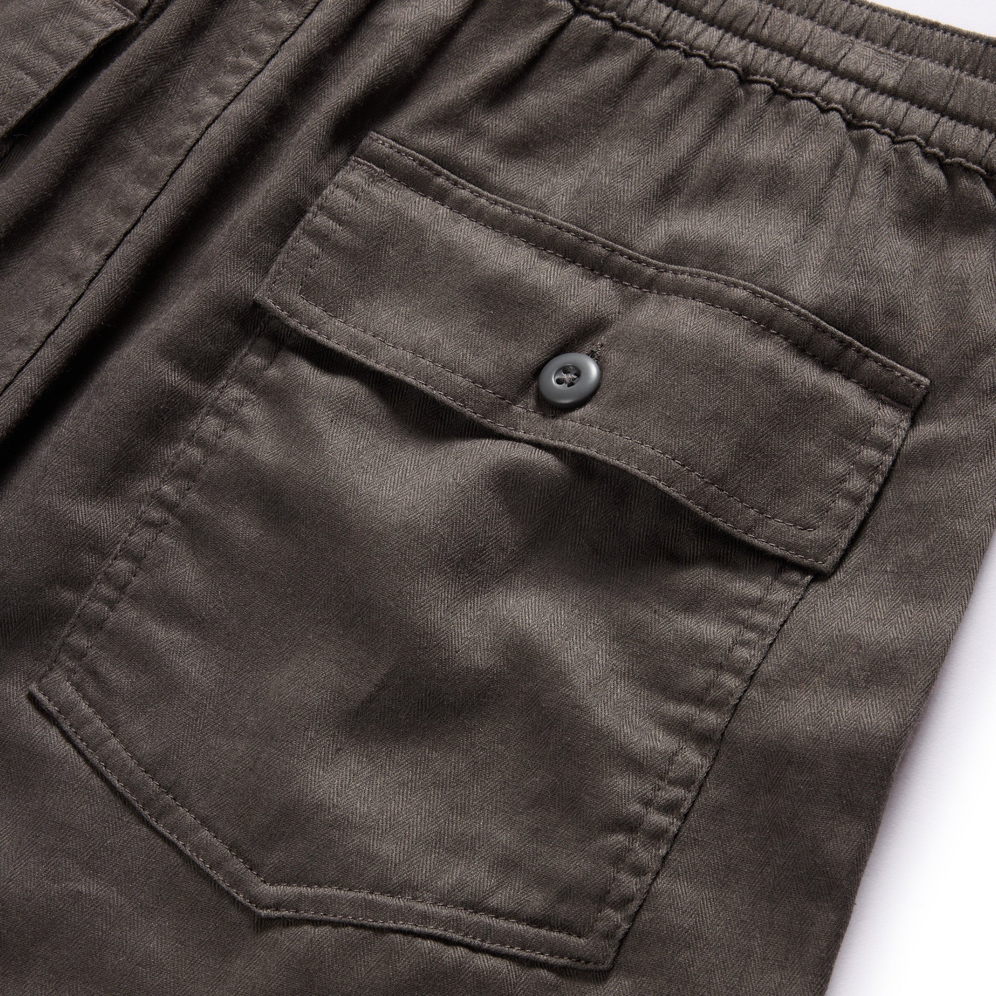 material shot of the back buttoned flap pockets on The Apres Trail Short in Granite Double Cloth, Bottoms by Taylor Stitch