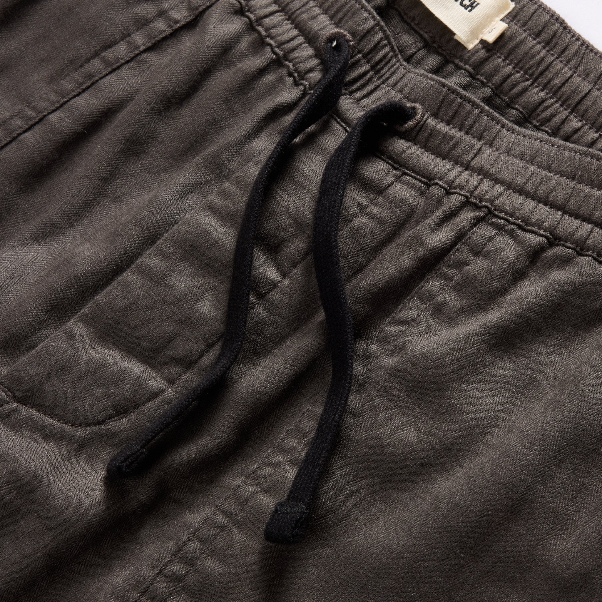 material shot of the drawcords and elasticated waist on The Apres Trail Short in Granite Double Cloth, Bottoms by Taylor Stitch