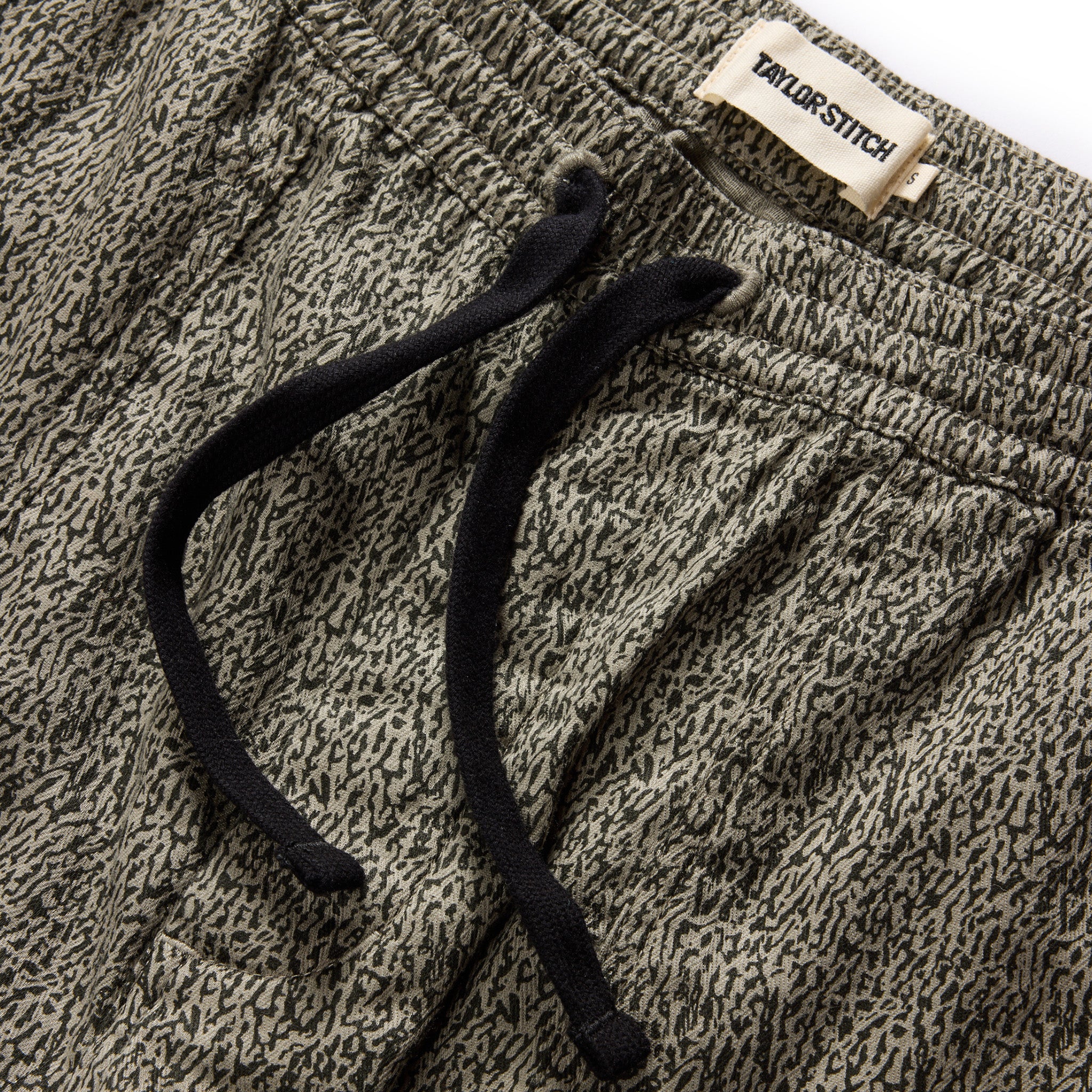 material shot of the drawcords and elasticated waist on The Apres Trail Short in Static Camo Double Cloth, Bottoms by Taylor Stitch