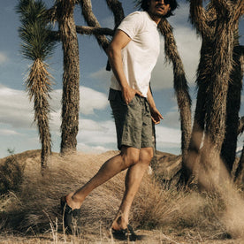 fit model walking amidst palms in The Apres Trail Short in Static Camo Double Cloth