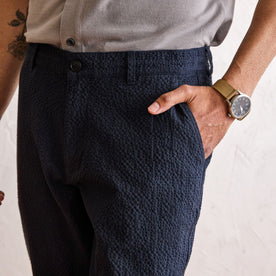 fit model with his hand in the pocket of The Easy Pant in Heather Navy Seersucker