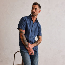 fit model posing by a metal chair in The Short Sleeve California in Navy Hemp