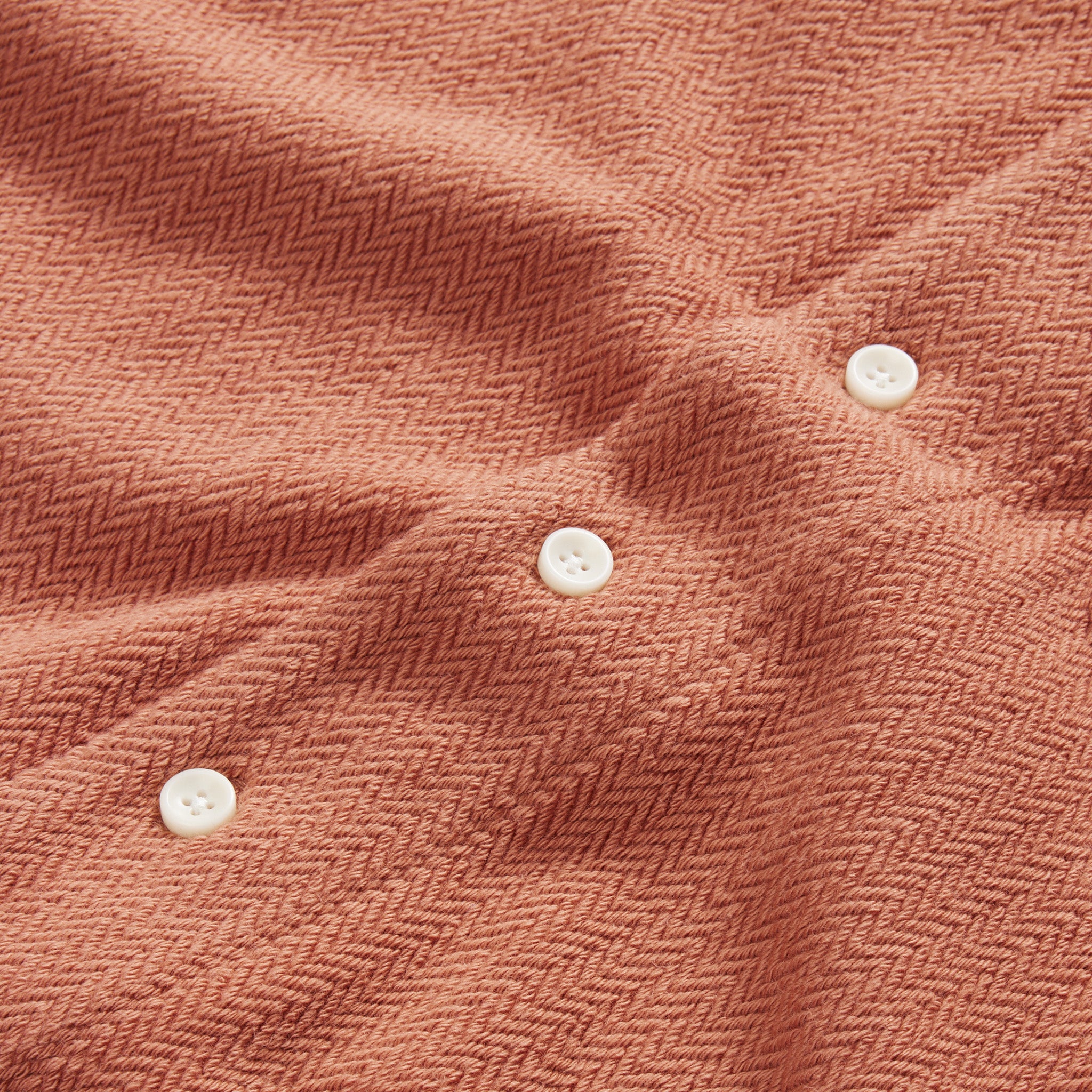 material shot of the natural buttons on The Latigo Shirt in Copper Herringbone, Knits by Taylor Stitch
