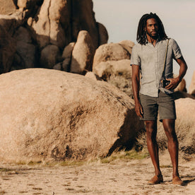 fit model posing by the rocks wearing The Camp Short in Coal Chipped Canvas