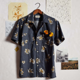 editorial image of The Conrad Shirt in Dark Blue Floral in front of drawings