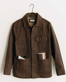 editorial image of The Fremont Jacket in Aged Penny Chipped Canvas on a hanger, Outerwear by Taylor Stitch
