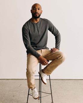 fit model sitting on a stool wearing The Heavy Bag Henley in Heather Grey, Knits by Taylor Stitch