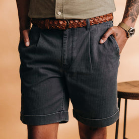 fit model with his hands in his pockets wearing The Matlow Short in Dark Navy Herringbone