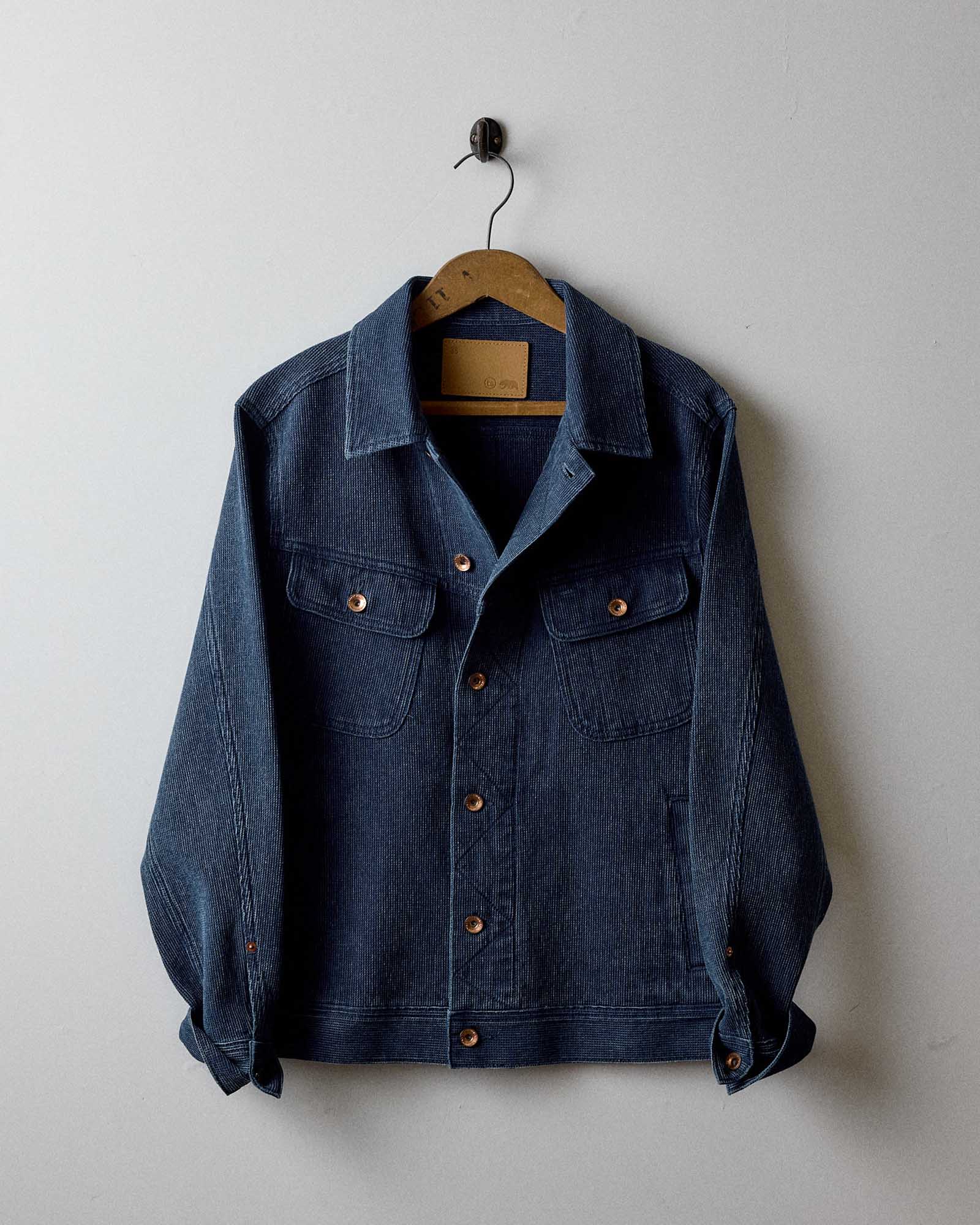 The Long Haul Jacket in Rinsed Indigo Waffle hanging on the wall, Outerwear by Taylor Stitch