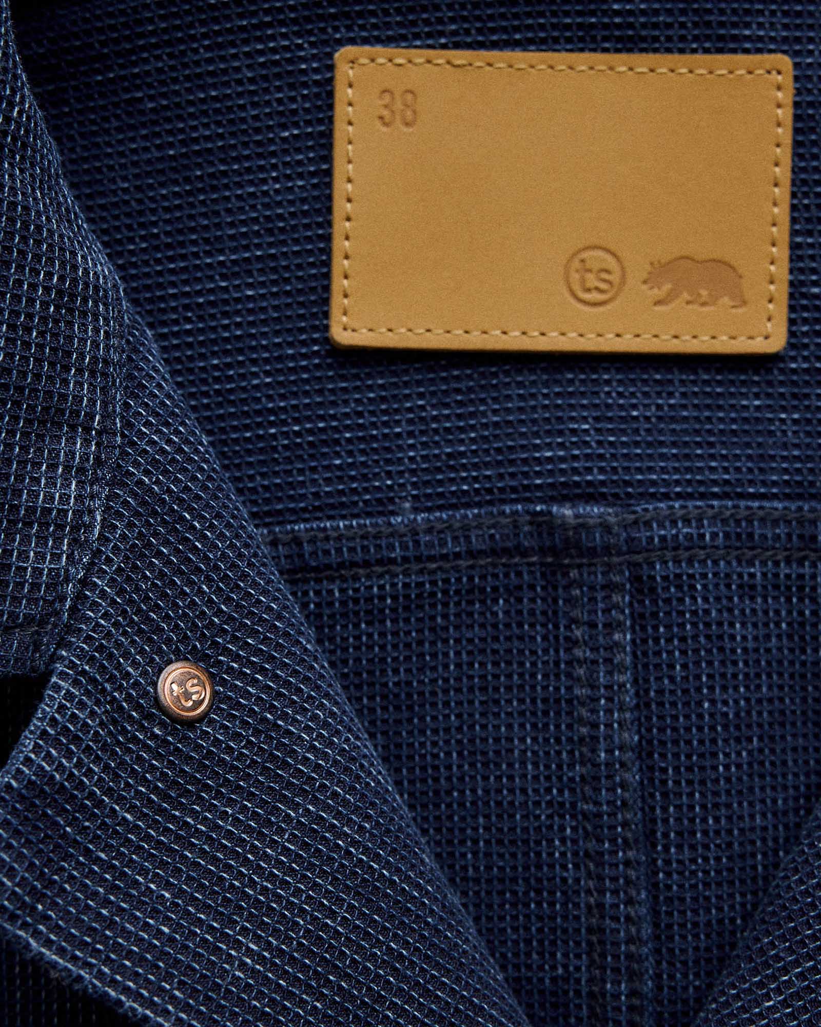 Close up of the leather label on The Long Haul Jacket in Rinsed Indigo Waffle, Outerwear by Taylor Stitch