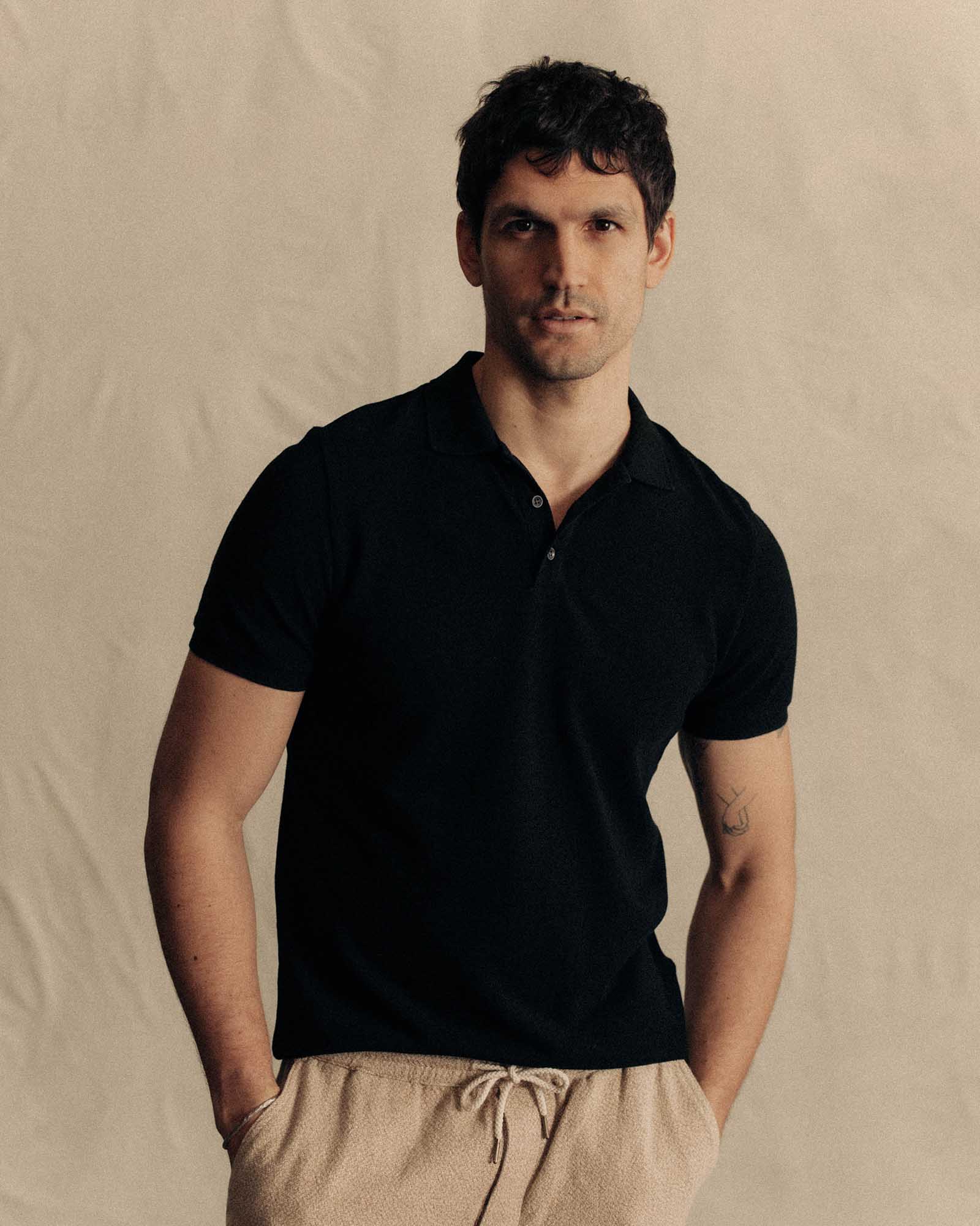fit model posing in The Pacific Polo in Black Indigo Pique, Knits by Taylor Stitch