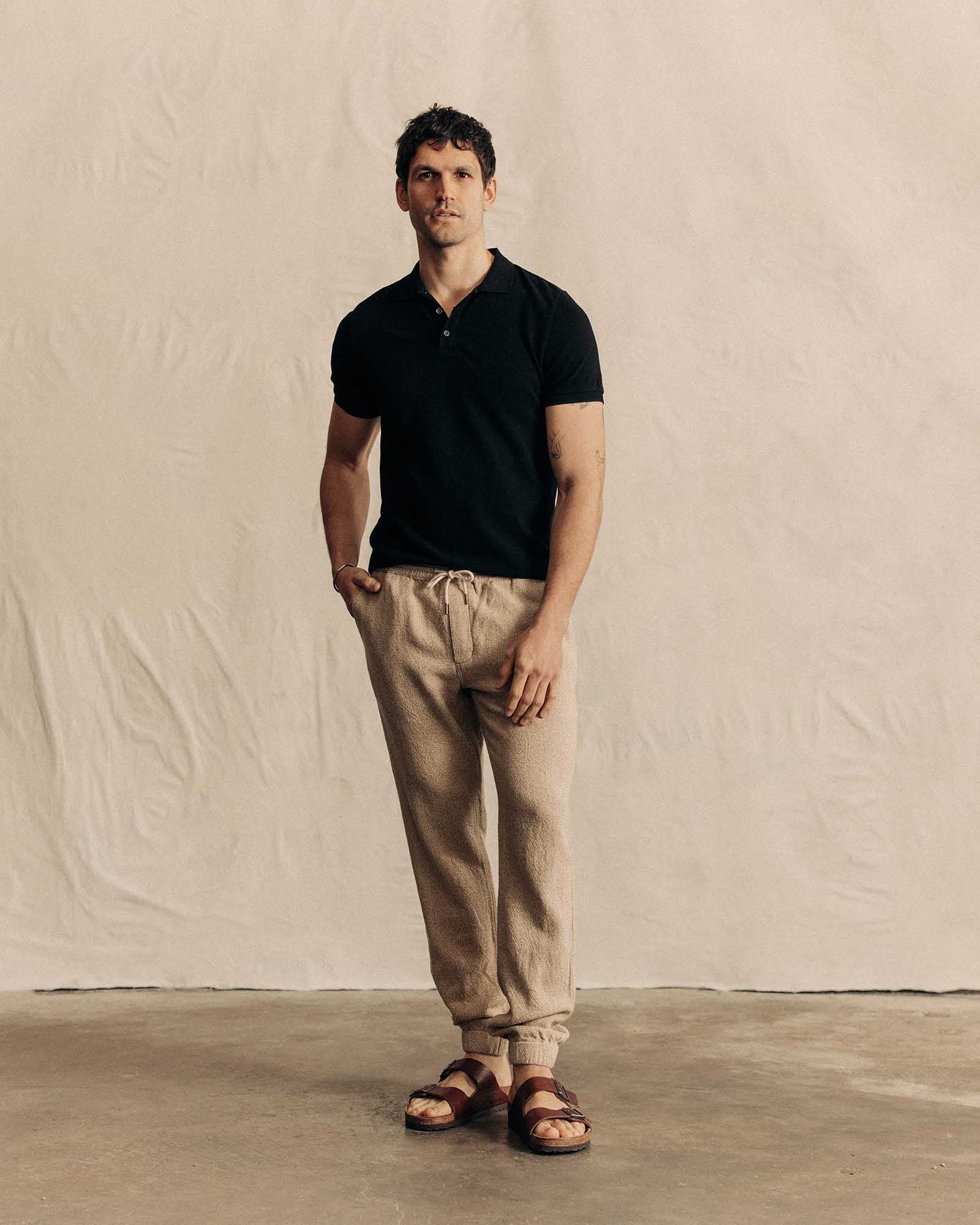 fit model standing wearing The Pacific Polo in Black Indigo Pique, Knits by Taylor Stitch