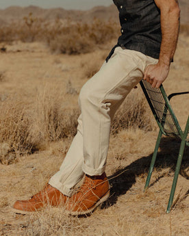 fit model sitting wearing The Painter Pant in Seeded Natural Chipped Canvas, Bottoms by Taylor Stitch