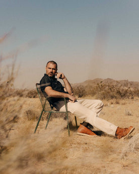 fit model sitting wearing The Painter Pant in Seeded Natural Chipped Canvas, Bottoms by Taylor Stitch