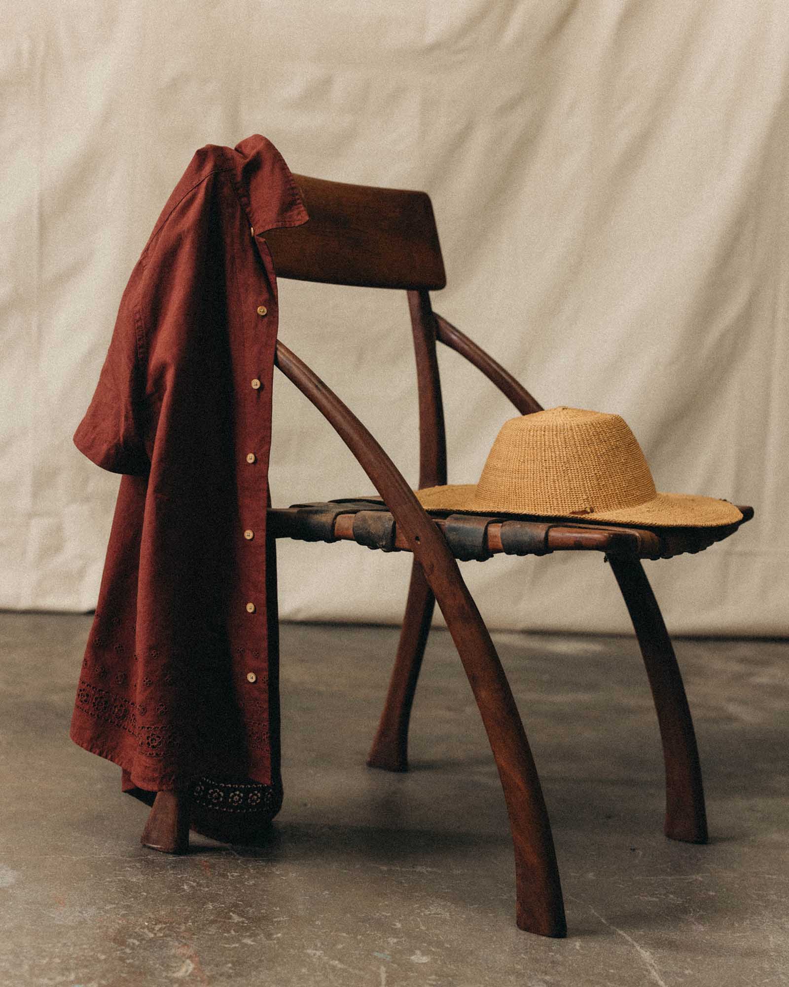 editorial image of The Hawthorne Shirt in Red Wine Border Eyelet hanging on a chair, Wovens by Taylor Stitch