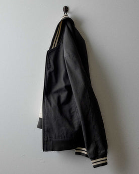 editorial image of The Speedway Bomber in Organic Faded Black Twill hanging, Outerwear by Taylor Stitch