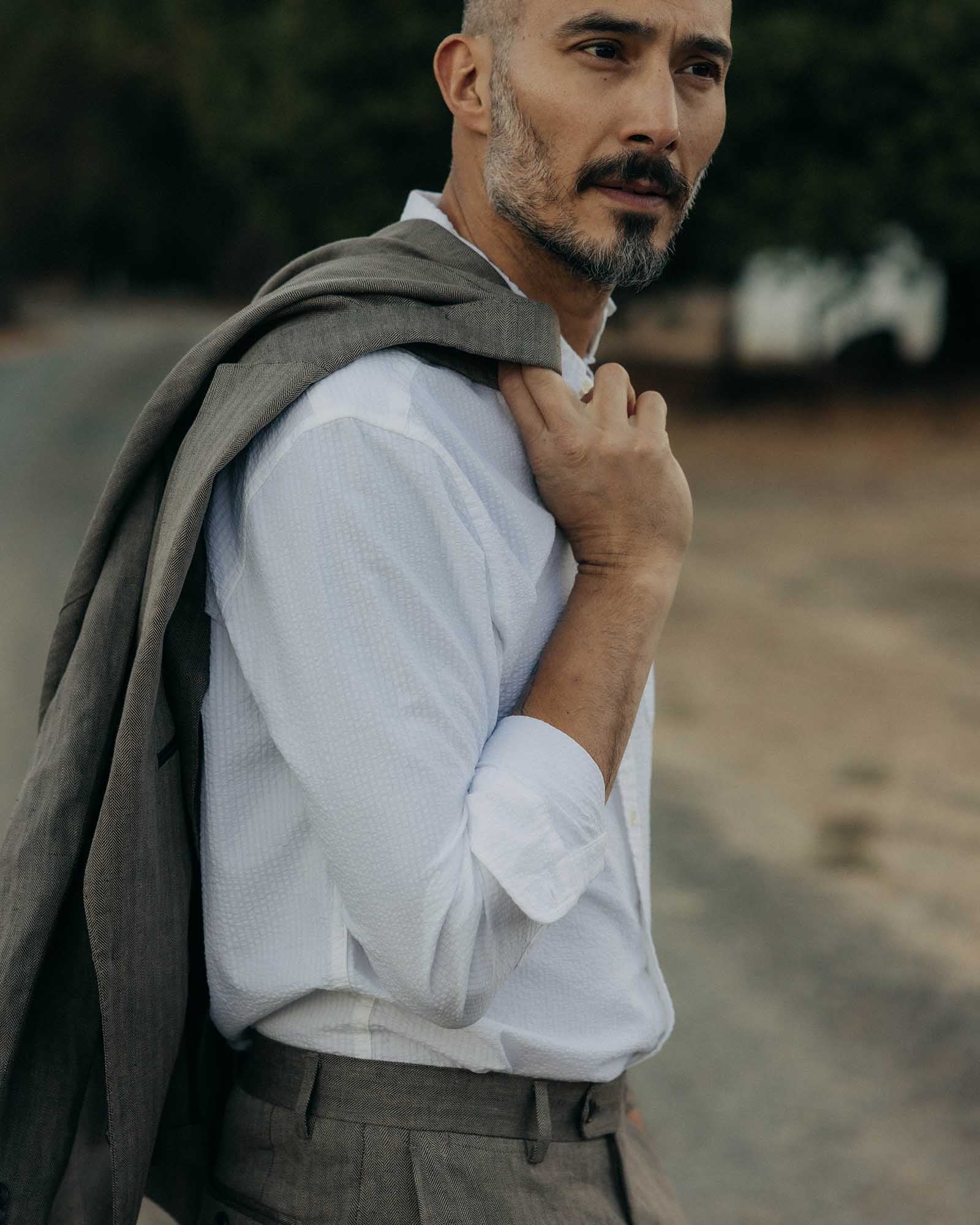 fit model with The Stevens Sportcoat in Coffee Linen Herringbone over his shoulder, Outerwear by Taylor Stitch