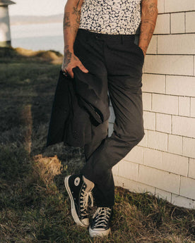 fit model leaning against the wall wearing The Stevens Trouser in Navy Linen Seersucker, Bottoms by Taylor Stitch