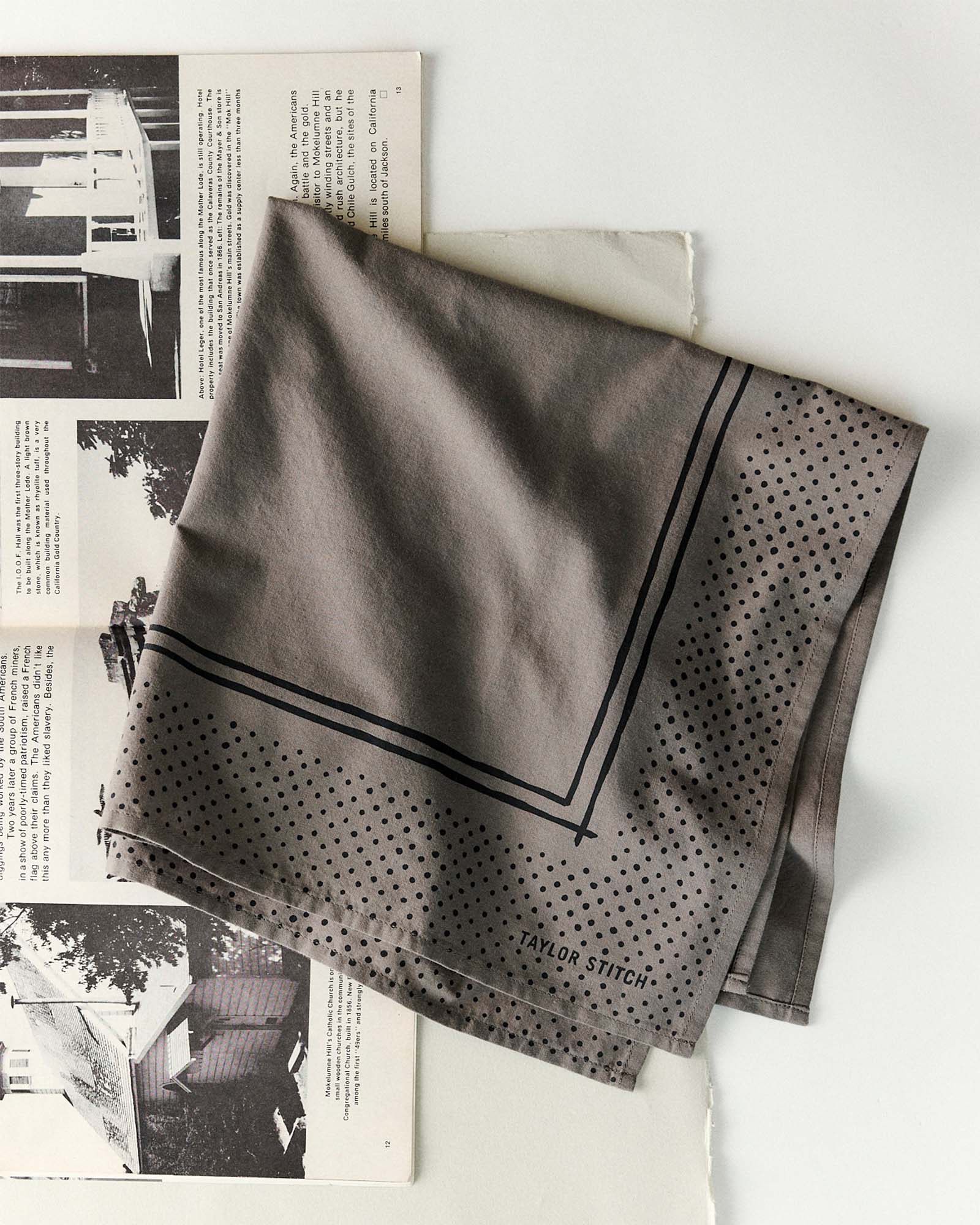 editorial flatlay of The Bandana in Smoked Olive Pindot folded, Accessories by Taylor Stitch