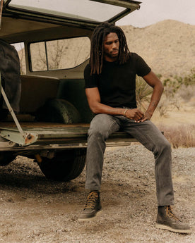 fit model sitting in a car wearing The Organic Cotton Tee in Black Indigo, Knits by Taylor Stitch