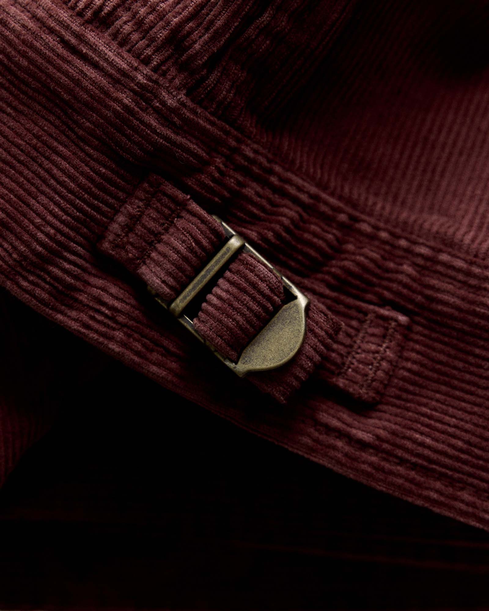 material shot of the buckle on The Piston Jacket in Dried Cherry Corduroy, Outerwear by Taylor Stitch