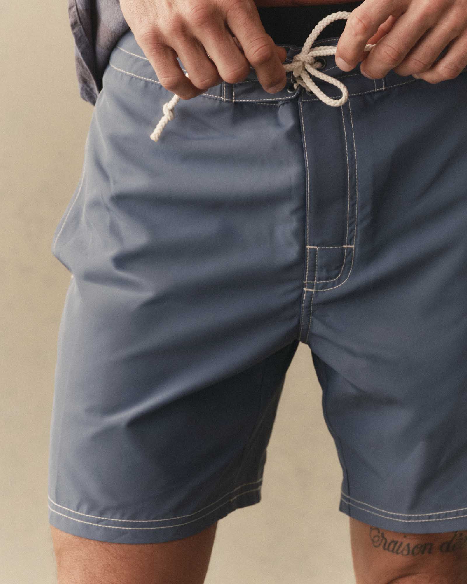 fit model tying The Drift Boardshort in Bluefin, Bottoms by Taylor Stitch