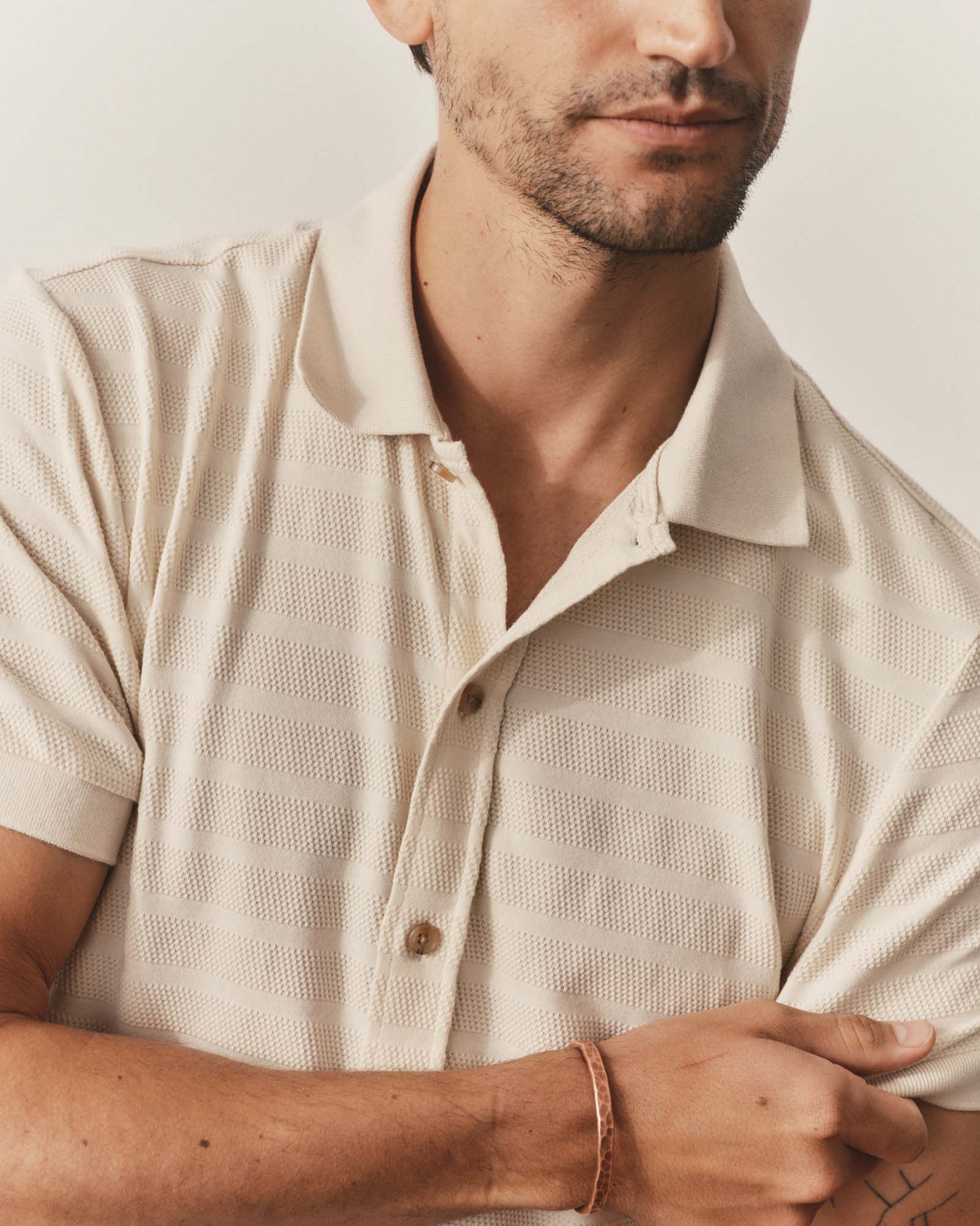 fit model posing in The Bywater Polo in Natural Knit Stripe, Knits by Taylor Stitch