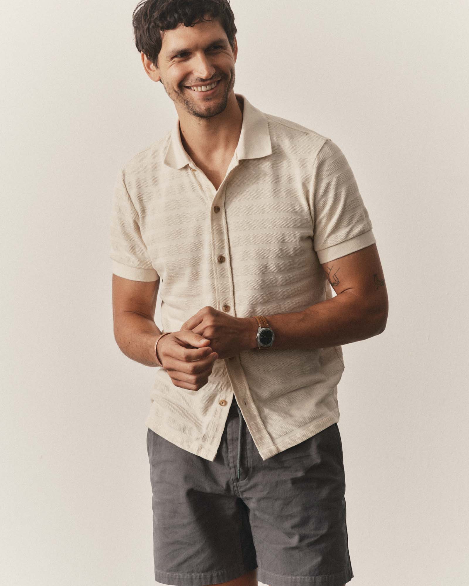 fit model posing in The Bywater Polo in Natural Knit Stripe, Knits by Taylor Stitch