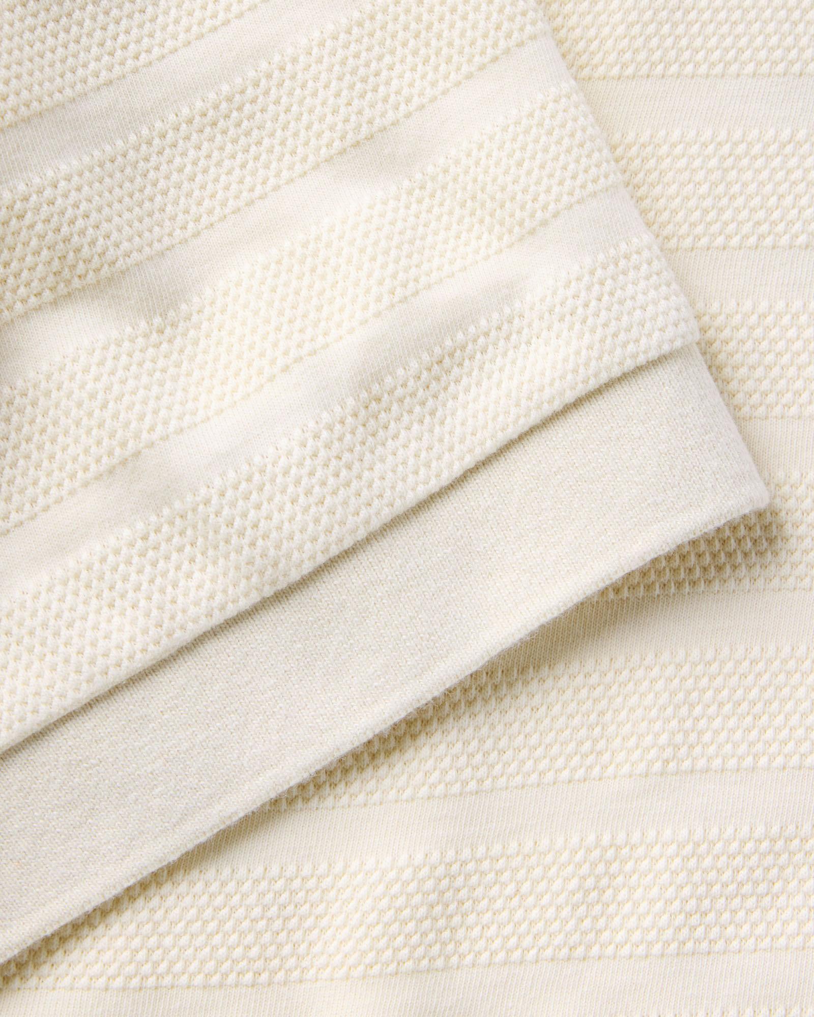 material shot of the sleeve on The Bywater Polo in Natural Knit Stripe, Knits by Taylor Stitch
